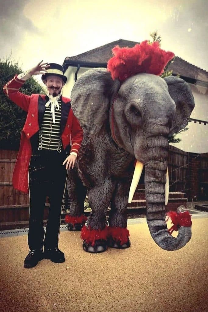An elephant stood with circus ringmaster