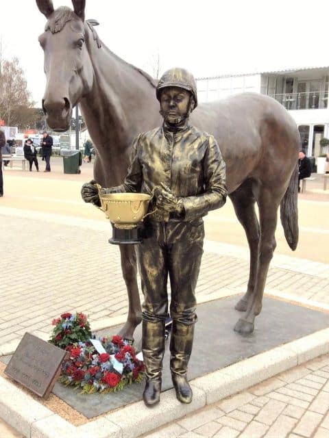 Human statue of a jockey stood beside racehorse